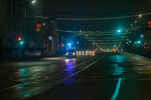 Tula, Russia - December 31, 2020: Ambulance car moving toward camera on empty night street in city.