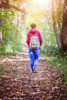 Young woman is walking through the forest, spring time