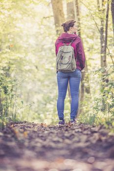 Young woman is walking through the forest, spring time