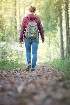 Young woman is walking through the forest, spring time