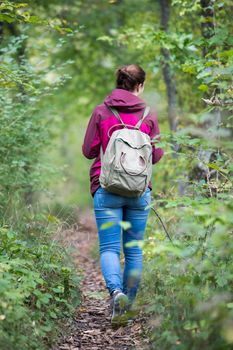 Young woman is walking through the forest, spring time