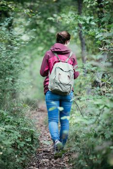 Young woman is walking through the forest, spring time