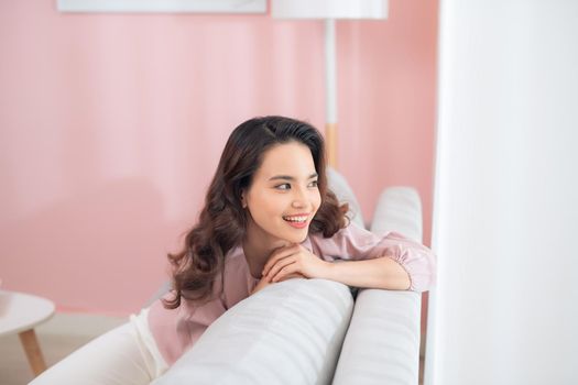 Young Asian woman sitting on couch and relaxing.