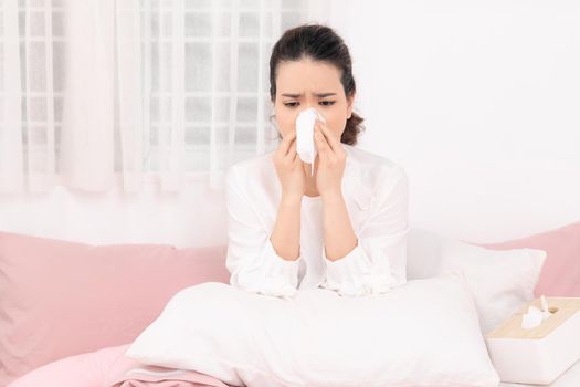 Sick woman with seasonal infections, flu, allergy lying in bed. 