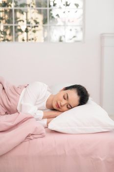 Young beautiful woman sleeping in her bed and relaxing in the morning