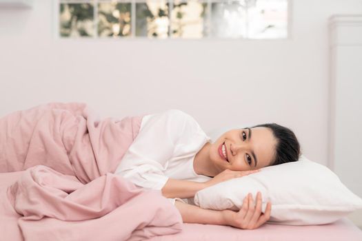 Awakening from sleep happy woman in bed and soft pillow blanket