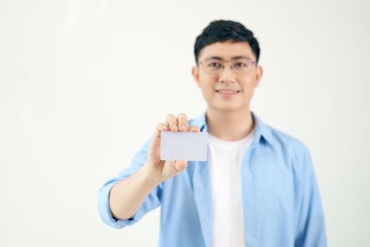 Portrait of smiling Asian man holding white blank business card on white background