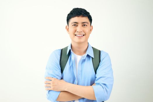 Young man standing crossed arms wearing backpack on a white background.