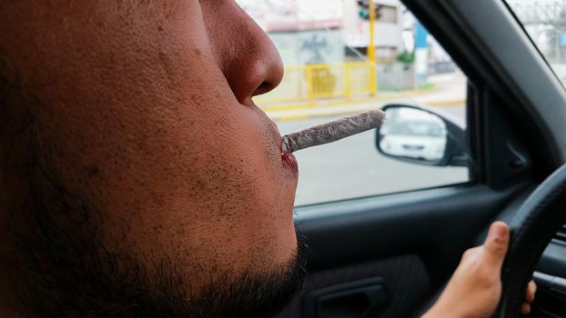 Man smoking marijuana cigarette soft drug in Lima - Peru
