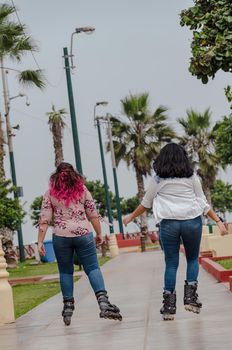 Two chubby girls with inline skates in the park happy