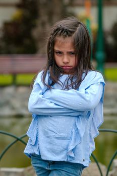 Angry little girl showing frustration and disagreement in the street