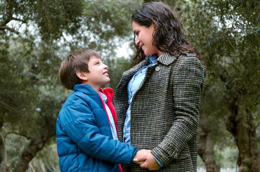 A little boy and his mother look at each other and laugh. Family composition