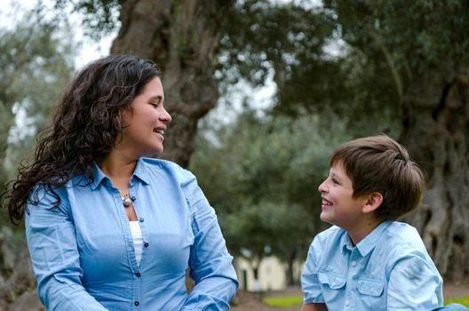 Beautiful woman and her cute little son looking at each other laughing