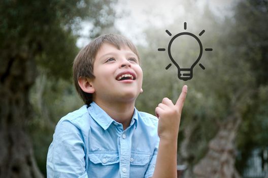 Portrait child with blond hair has an idea, pointing with finger up looking up