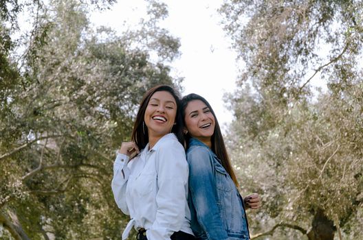 Two women best friends smiling over park background a day of autumn