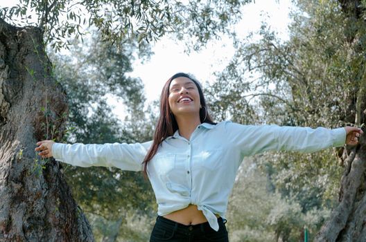 Woman smiling looking up to blue sky taking deep breath celebrating freedom. Positive human emotion face expression feeling life perception success peace mind concept. Free Happy girl enjoying nature