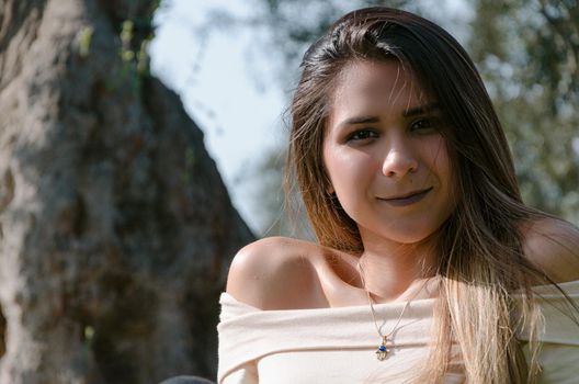 Beautiful smiling teenage girl, against green of summer park.