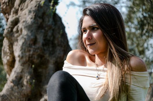 Beautiful smiling teenage girl, against green of summer park.