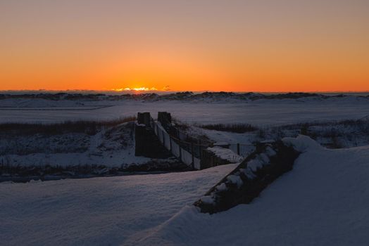 Bridge used for hiking in the beach area - sunset and snow at winter