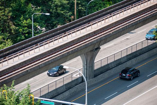 Modern cityscape. Fragment of four lane asphalt road with skytrain path above
