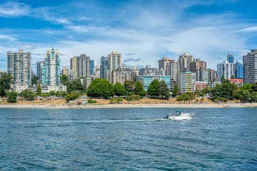 View on old part of Vancouver downtown over Coal harbor. Downtown view with mountains and cloudy sky on the background