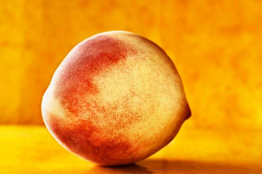 A peach on colored background still life  , macro photography