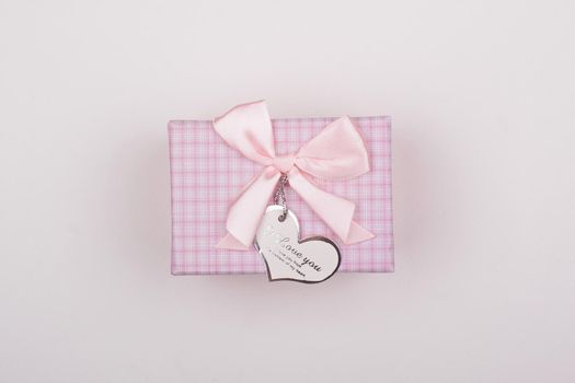 Pink gift with bow on a white background. Heart note I love You. 