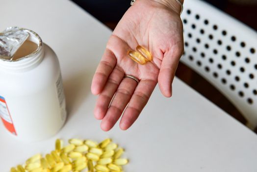 Hand holding fish oil Omega-3 capsules. Medical healthcare, healthy nutrition supplements concept. Vitamin tablets.