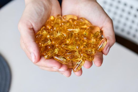 Hands holding fish oil Omega-3 capsules. Medical healthcare, healthy nutrition supplements concept. Vitamin tablets.