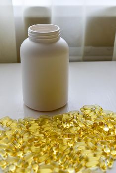 Fish oil capsules with omega 3 and vitamin D in a bottle on wooden texture, healthy diet concept,close up shot.