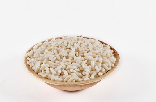 Puffed rice in an areca leaf bowl on a white background