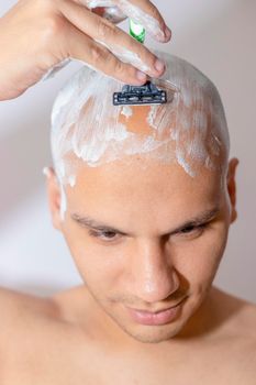 Man Shaving His Head Using White Foam