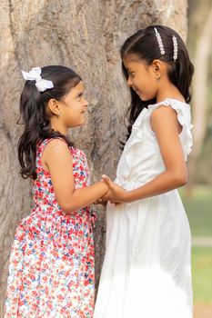 Tender little sisters hugging each other and showing their true love