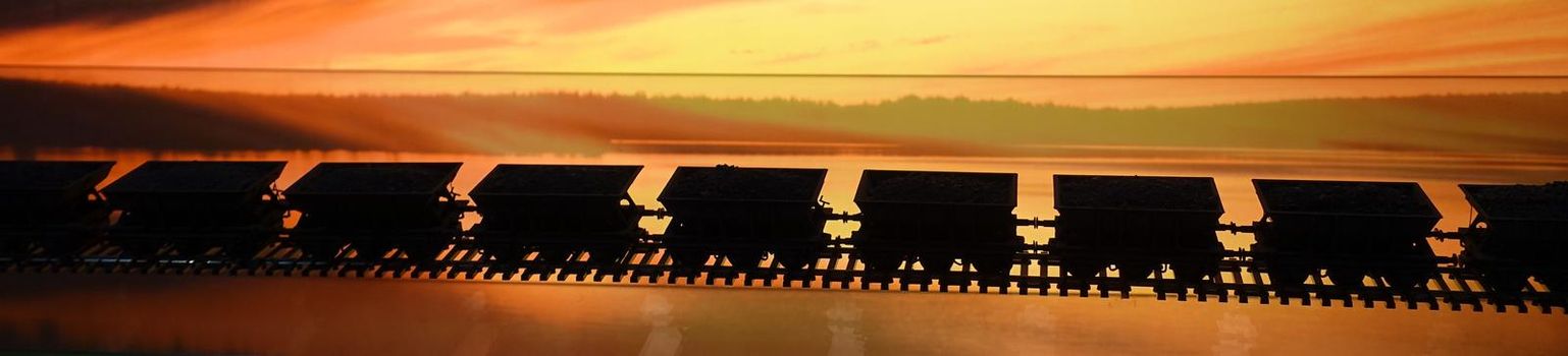 photos of the wagons of a freight train parading on the rails during sunset