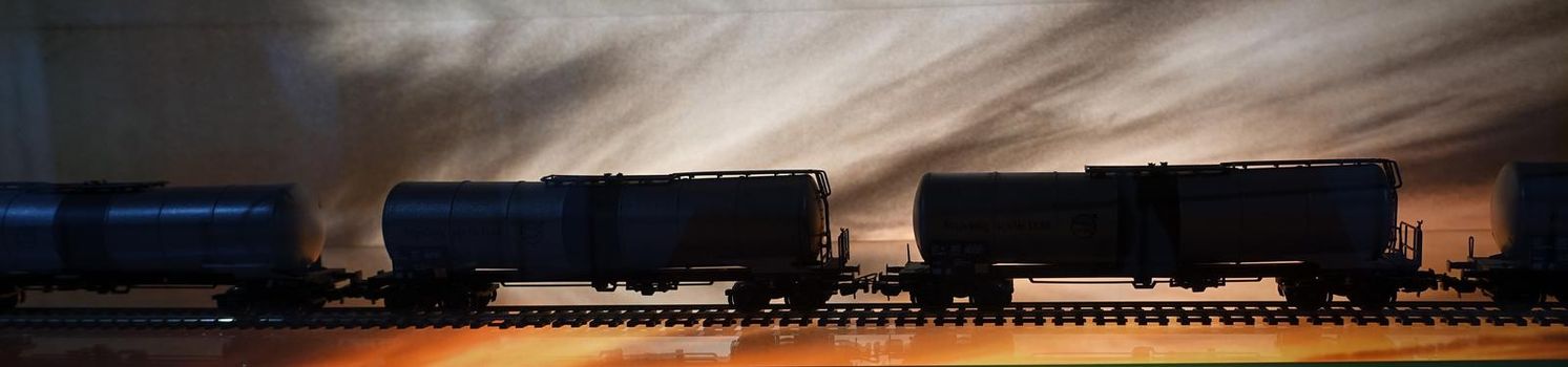 photos of the wagons of a freight train parading on the rails during sunset
