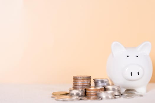 Piggy bank with stack coins isolated orange background. Saving money and investment concept.