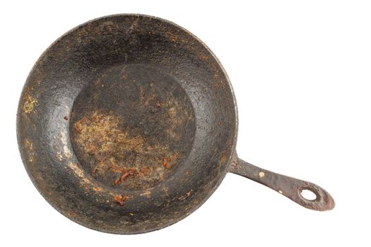 old disgusting stained rusty cast iron pan with burnt fat isolated in directly above perspective.