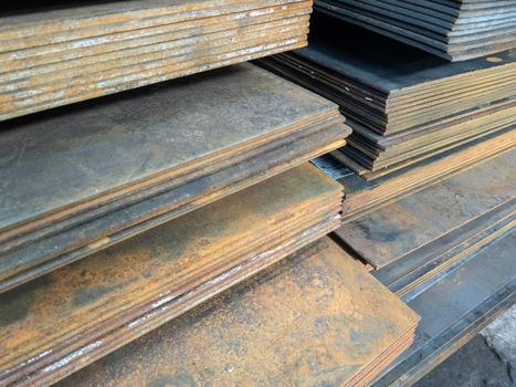 stacks of thick rusted flat metal sheets - close-up with selective focus