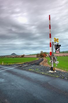 Rail crossing in Central Bohemian Uplands. Single railway track at sunset, Czech Republic