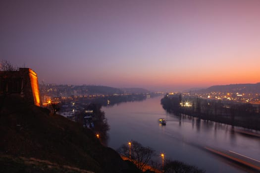 Small dock, boats and Vltava River in Prague, Czech Republic, viewed from the Vysehrad fort in the dramatic sunset.