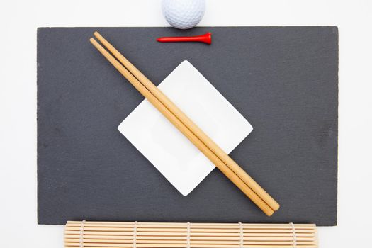 Rectangular slate plate with chopsticks for sushi and golf tee.  Golf Design