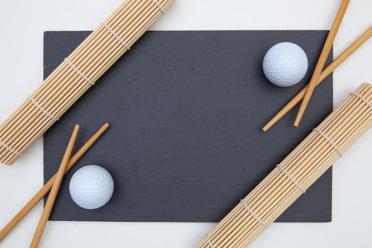 Rectangular slate plate with chopsticks for sushi and golf ball. Golf Design