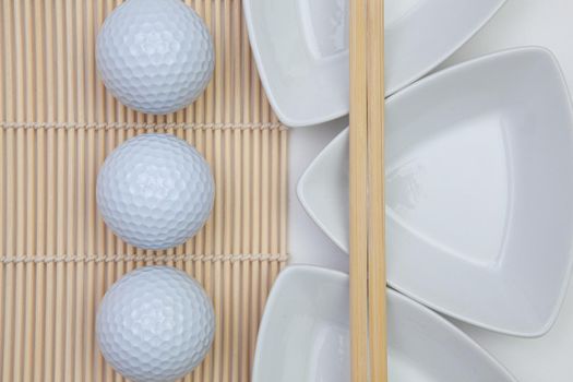 Top View Of White Empty Sushi Plates With Bamboo Chopsticks and Golf Balls. Golf  Design