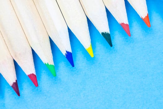 Multicolored pencils on blue background , wooden pencils with colored points in a row ,studio shot