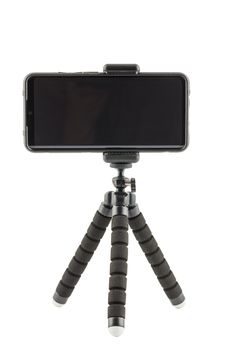 black cellphone in rugged rubber protective cover on small flexible tripod isolated on white background