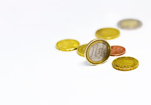 One euro coin standing together with various coins isolated on a white background. Economics and finance. European union currency