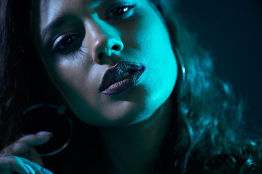 Close up portrait of beautiful woman with stylish makeup and accessories in dark blue light. Concept of fashion model on shooting for modern beauty magazine.