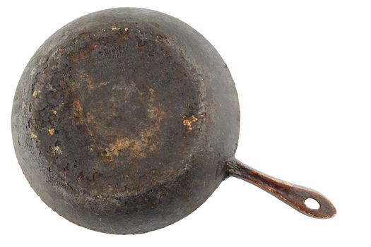 old stained rusty cast iron pan with burnt fat isolated on white bottom up in flat lay perspective.