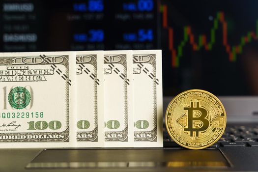 Bitcoins coin and banknotes on keyboard computer. Close up of  bitcoin crypto currency coins with trading exchange market price chart in the background