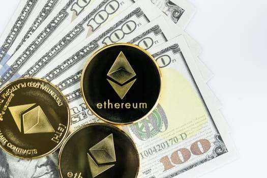 Ethereum coin and  US banknotes of one hundred dollars. Close up of metal shiny Ethereum crypto currency coins and US dollar